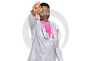 Young african american woman wearing doctor uniform and stethoscope looking unhappy and angry showing rejection and negative with