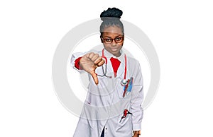 Young african american woman wearing doctor uniform and stethoscope looking unhappy and angry showing rejection and negative with