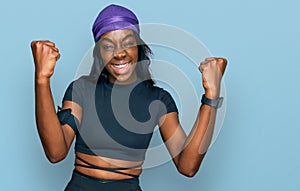 Young african american woman wearing sportswear screaming proud, celebrating victory and success very excited with raised arms