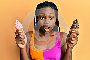 Young african american woman wearing summer style holding ice cream afraid and shocked with surprise and amazed expression, fear
