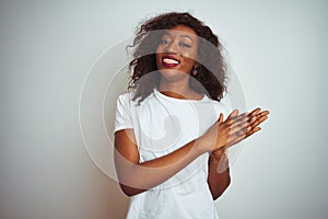 Young african american woman wearing t-shirt standing over isolated white background clapping and applauding happy and joyful,