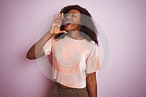 Young african american woman wearing t-shirt standing over  pink background shouting and screaming loud to side with hand