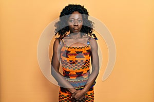 Young african american woman wearing traditional african clothes depressed and worry for distress, crying angry and afraid