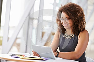 Young African American woman working with tablet in office