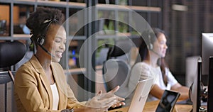 Young African American woman works at her desk in a business office