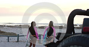 Young African American woman and young Caucasian woman head to the beach, with copy space