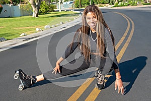 Young African-American women with roller skates posses on the street