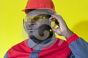 Young African-American Worker In Personal Protective Equipment Against Yellow Background