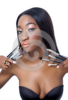 Young African beauty with make up brushes