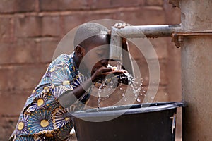 Joven chico bebiendo Agua comunidades Bueno mano bomba 