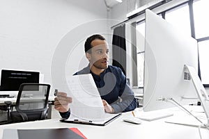 Young african business man sitting at his desk photo