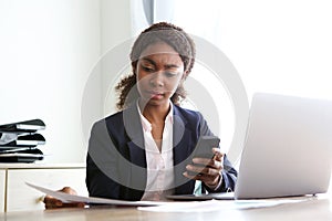 Young african business woman sitting at her desk and reviewing documents