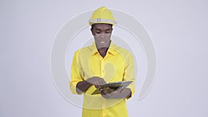 Young African businessman as engineer talking while reading on clipboard