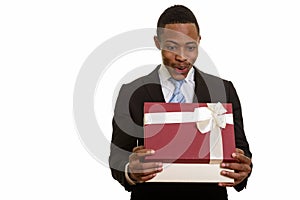 Young African businessman opening gift box and looking surprised