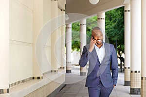 Young african businessman talking on mobile phone in the city