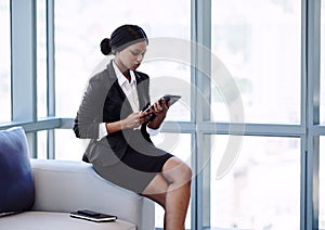 Young african businesswoman looking at the screen on her tablet