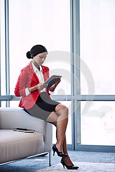 Young african businesswoman looking at the screen on her tablet