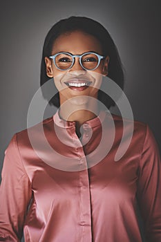 Young African businesswoman smiling while standing against a gra