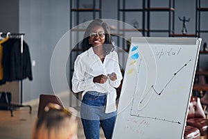 Young african businesswoman stand talking explaining making flip chart presentation