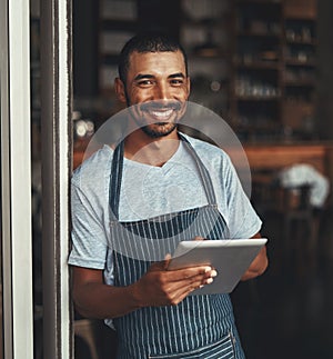 A young african cafe entrepreneur holding digital tablet