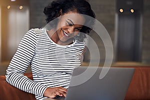 Young African college student smiling and using a laptop