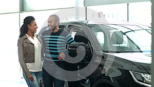 Young African couple choosing a car at the car salon