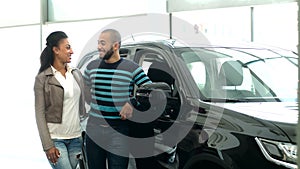 Young African couple choosing a car at the car salon