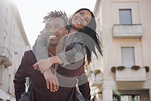 Young african couple having fun walking around the city - Focus on man face