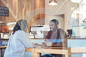 Young African couple talking together over coffee in a cafe