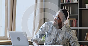 Young african ethnic male employee listening to energetic music.