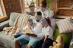 Young african family during quarantine, insulation spending time together at home