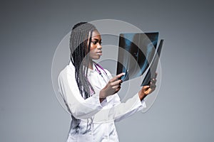 Young african Female doctor looking at an x-ray isolated on gray background