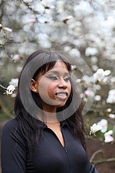 Young African girl with braces on a background of flowers