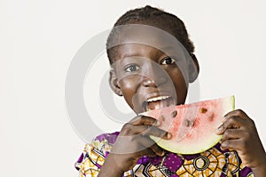 Young African girl eating some watermelon, isolated on white