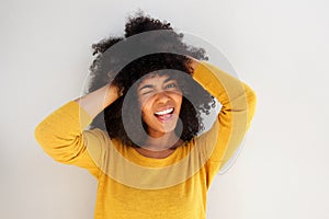 Young african girl laughing and winking against white background