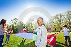 Young African girl playing parachute with friends