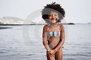 Young african girl smiling on camera outdoors at the beach - Focus on face