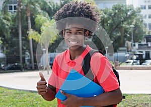 Young african male student showing thumb up