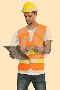 Young African man construction worker reading on clipboard