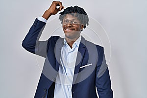 Young african man with dreadlocks wearing business jacket over white background dancing happy and cheerful, smiling moving casual