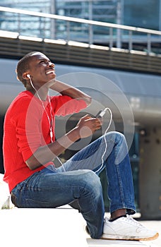 Young african man enjoying listening music on mobile phone