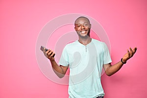 young african man feeling confident and assured holding his mobile phone and smiling