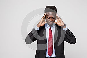 Young African man in formalwear touching his head with hands while standing against grey background