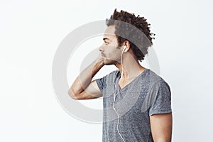 Young african man in headphones looking in side. Profile. White background. Copy space.