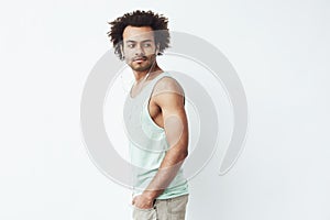 Young african man in headphones standing in profile looking in side. White background.