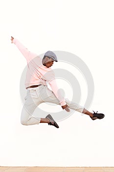 Young african man jumping in air on sidewalk outdoors