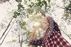 Young African man looking through binocular in the forest, Travel concept.