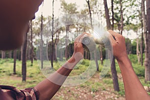 Young African man looking through binocular in the forest, Travel concept.