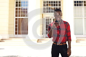 Young african man looking at mobile phone in the city