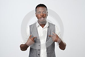 Young african man pointing at himself, making excuses or verbally defending, photo